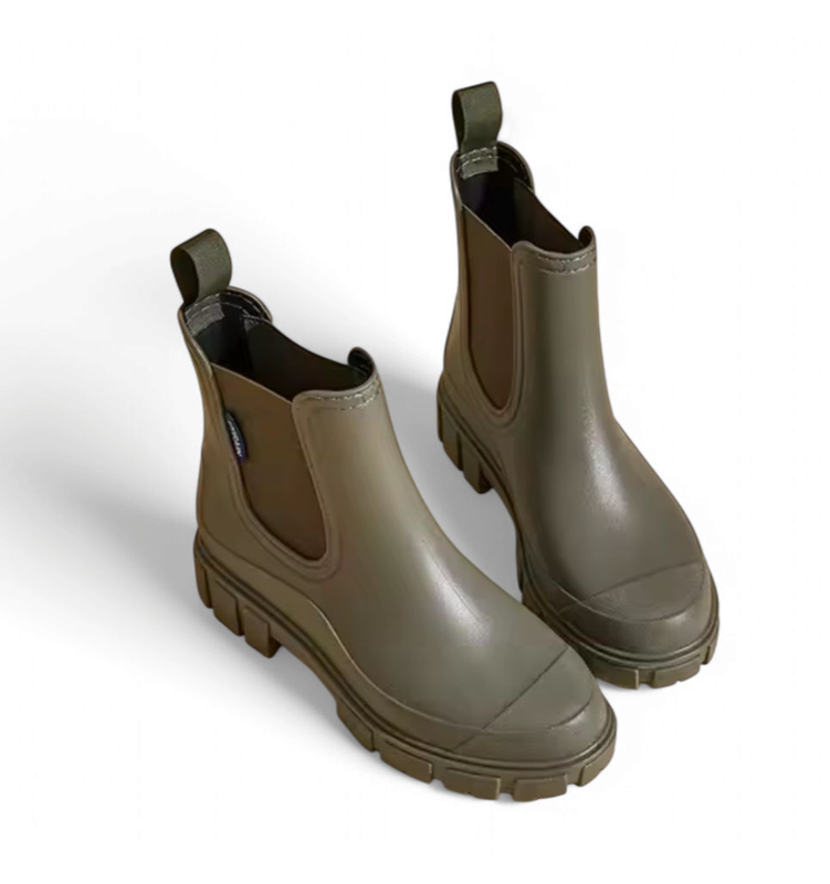 Pair of green chunky Chelsea boots viewed from a top-side angle on white background.