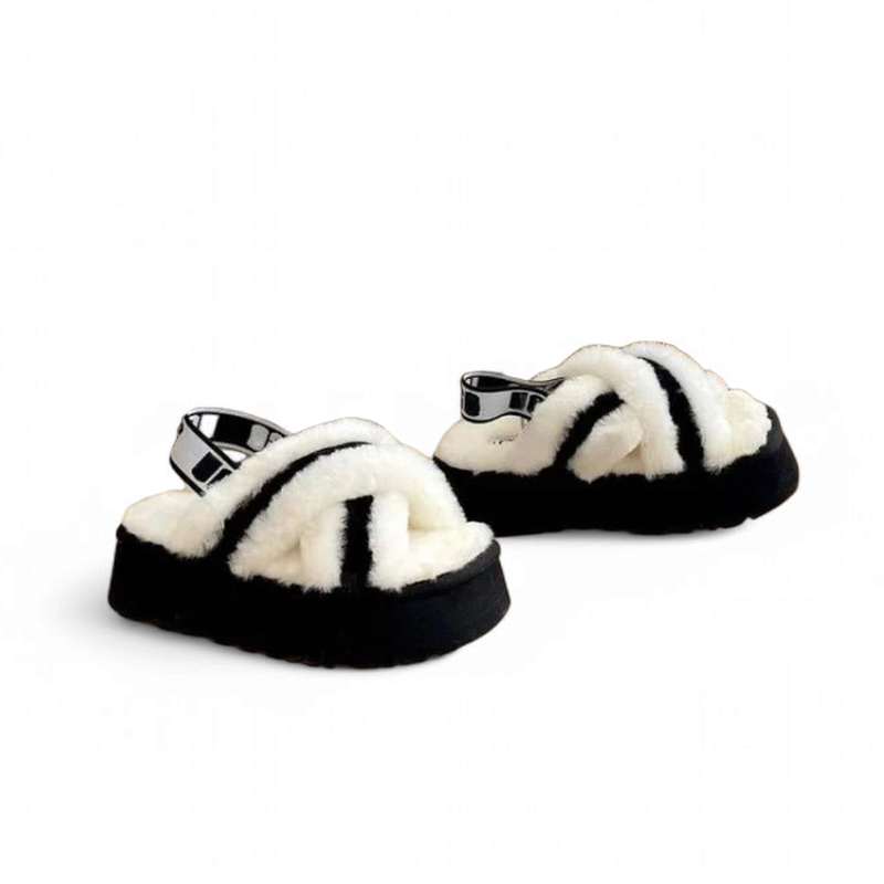Pair of black platform slippers with criss-cross faux fur straps and a branded elastic back band, displayed on a white background.