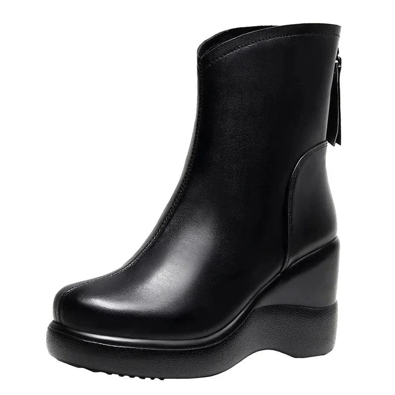 A black leather ankle boot with a square toe, wedge heel, and rear zipper, shown against a white background.