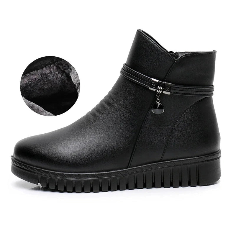 Side profile of a black ankle boot showing zip and plush lining cut‑out.