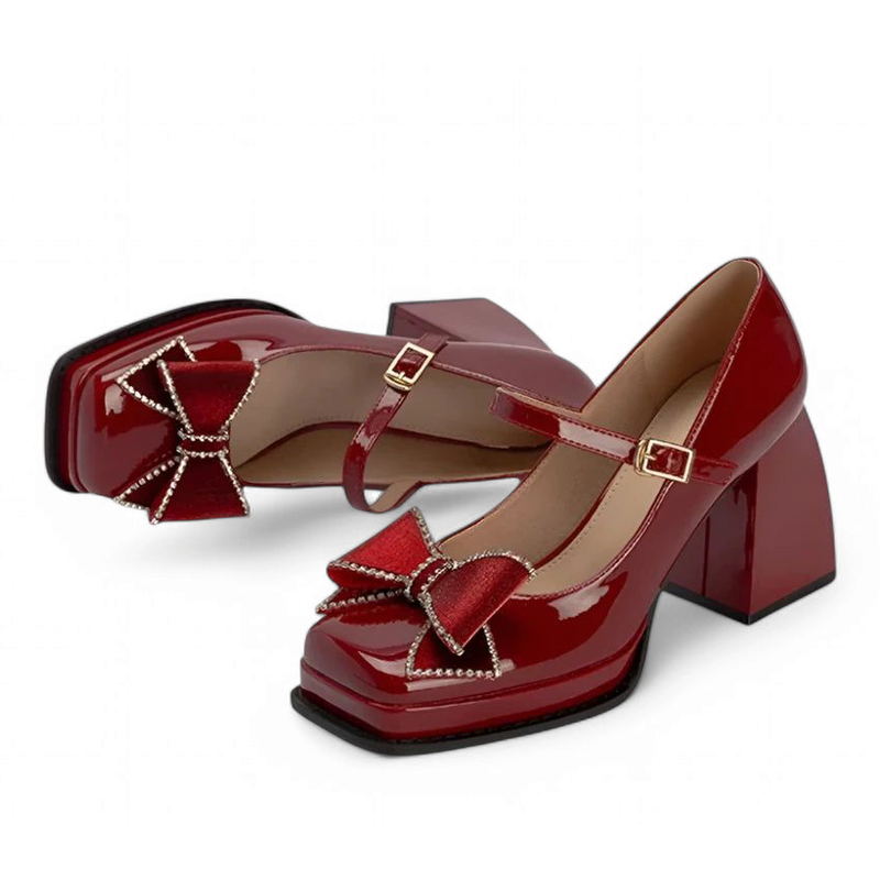 Two glossy burgundy patent pumps with square toes and Mary-Jane strap; one lying, one upright, angled front.
