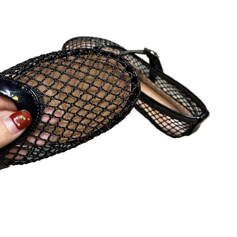 Hand bending the flexible black mesh toe of the loafer, close‑up