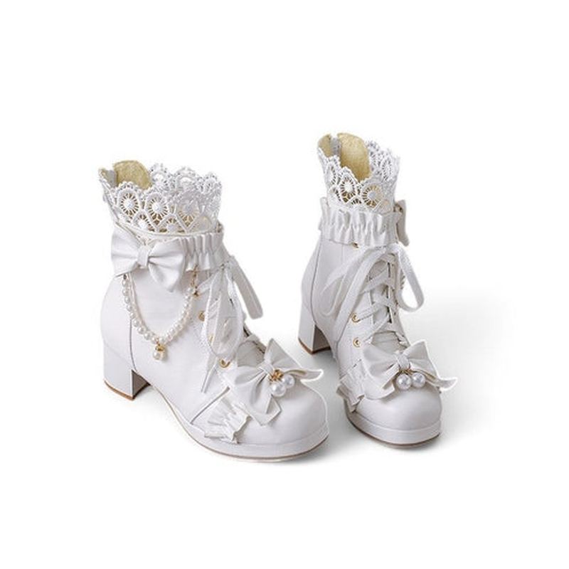 A full-frontal view of white Victorian-inspired boots with floral lace, pearl bows, and ruffled cuff details.