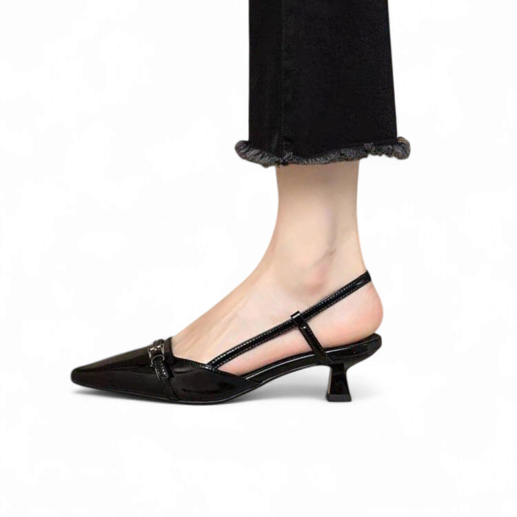 side view of a glossy black slingback pump featuring a pointed toe, a metallic front buckle detail, and a structured insole design.