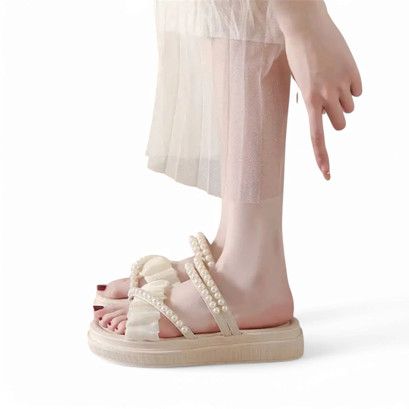 Ivory platform sandal with pearl trim and ruched fabric shown on model in tulle skirt, side view, white backdrop