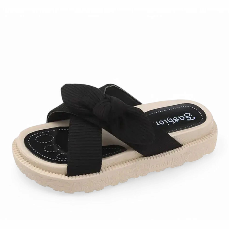Same knotted-strap design in black on a flat cream sole.