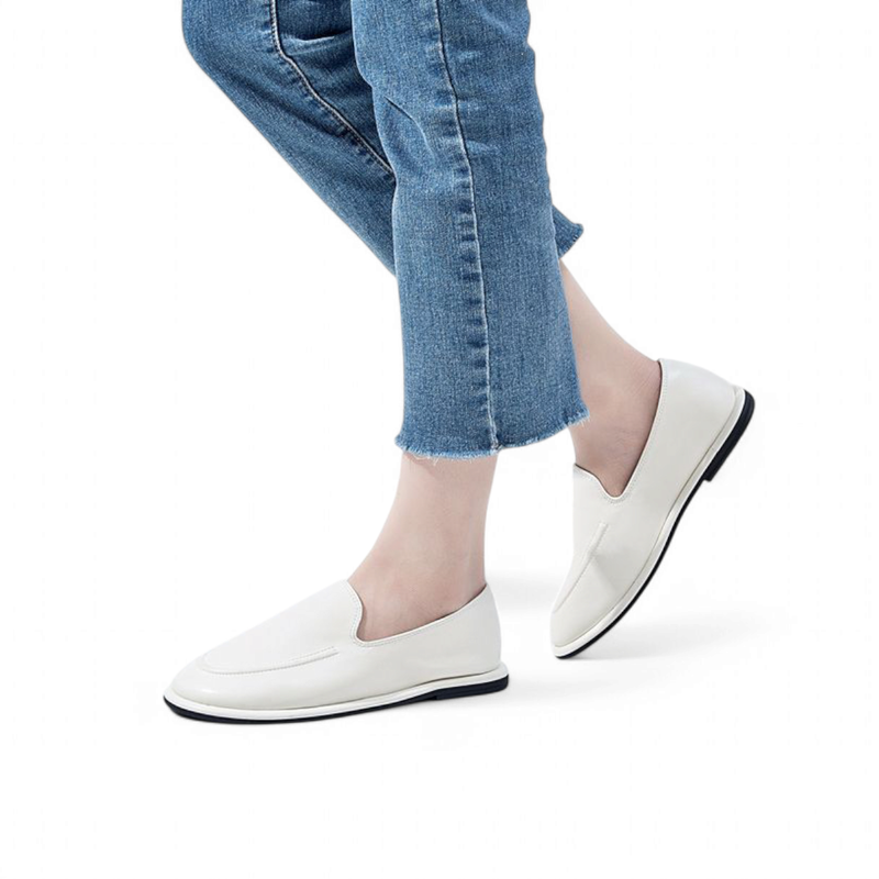 White leather round‑toe loafers worn with jeans, side view