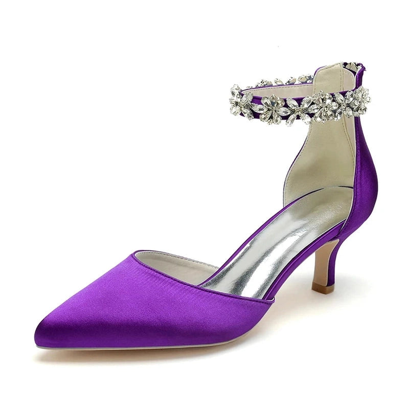 Purple pump with pointed toe, kitten heel and gem-studded ankle strap.