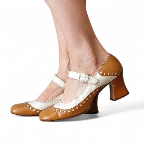 Side profile of caramel-and-ivory shoe, highlighting flared chunky heel and dotted trim along the lower edge.