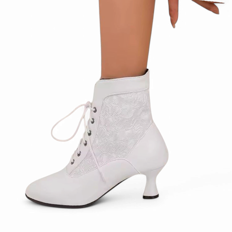 Side view of a single white Victorian-style ankle boot worn by a woman, showing the full lace-up design and kitten heel against a white background.