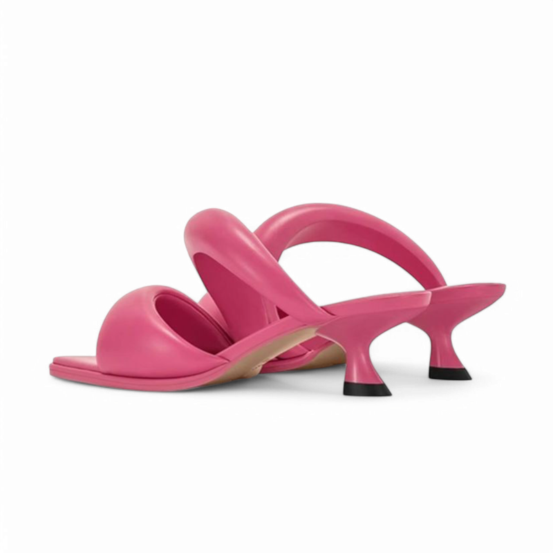 Rear three-quarter view of pink sandals highlighting flared heels and light leather sole.