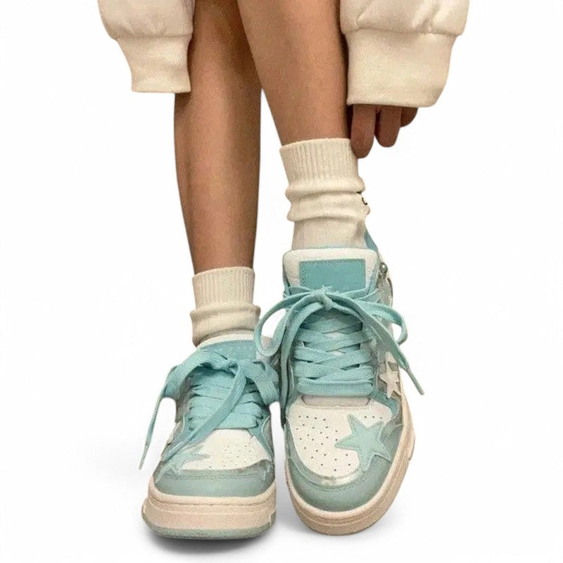White and sky-blue sneakers with long laces, worn with cream socks.
