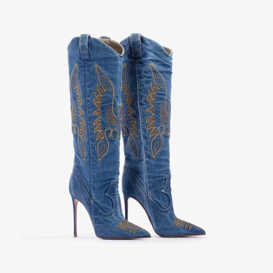 Three-quarter front view of embroidered denim boots, showcasing the shaft curve and high heel