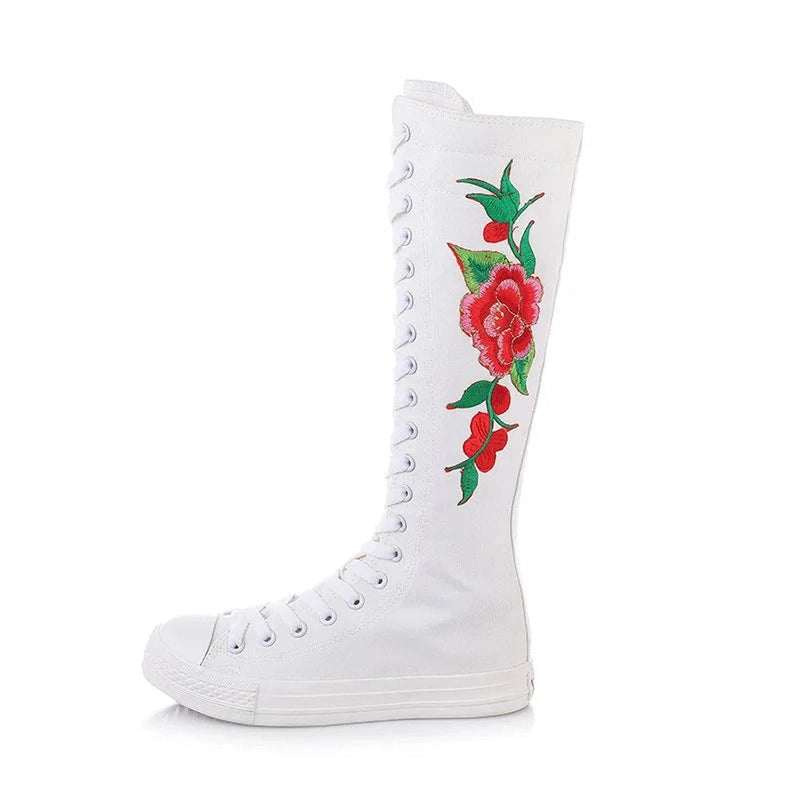 White knee-high canvas boot with red floral embroidery running down the shaft.