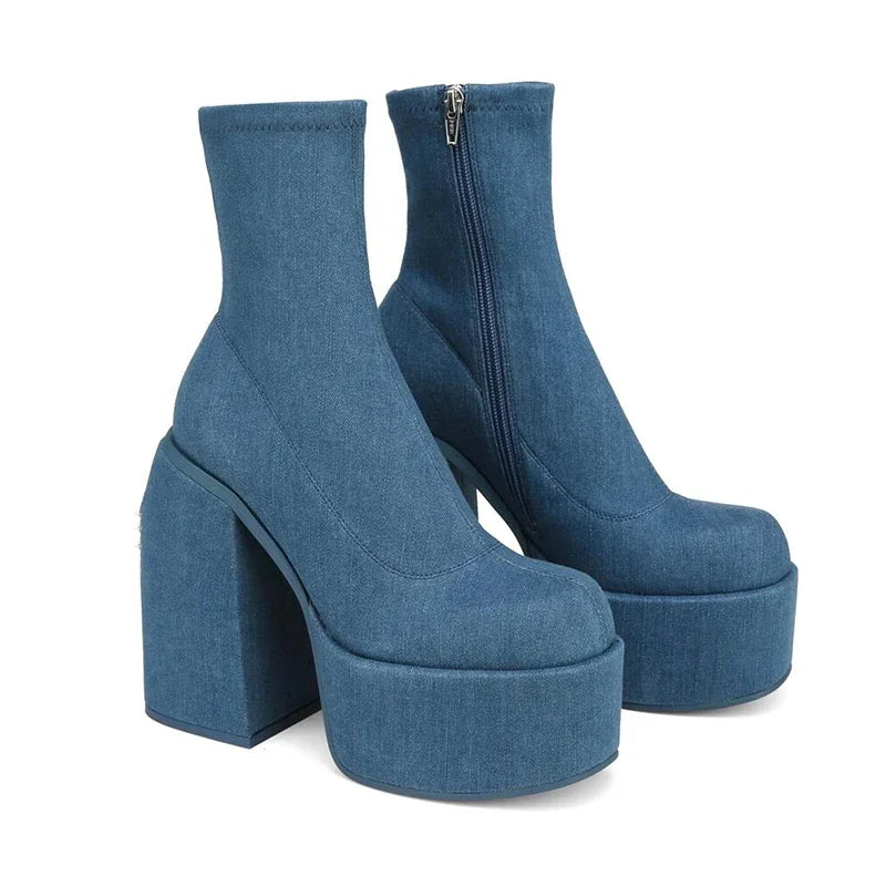 Pair of blue-denim ankle boots with extra-high block heels and bold platforms.