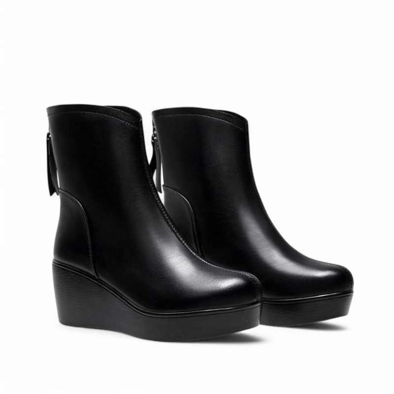 Side view of a pair of black wedge-heeled ankle boots placed next to each other, showing the leather upper, square toes, and platform soles against a white background.