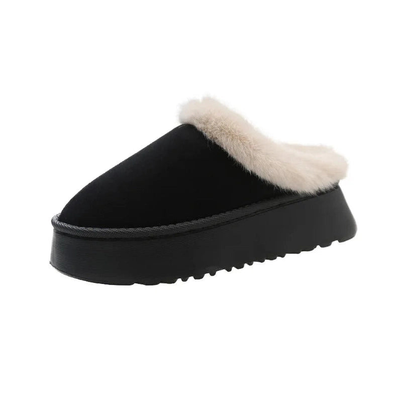 A black slip-on slipper with a subtle faux fur trim along the edge, shown from the side.