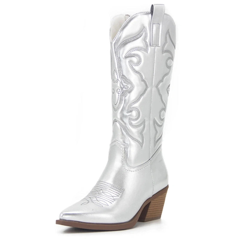 Shiny silver boot with western embroidery, pointed toe and sturdy brown heel.