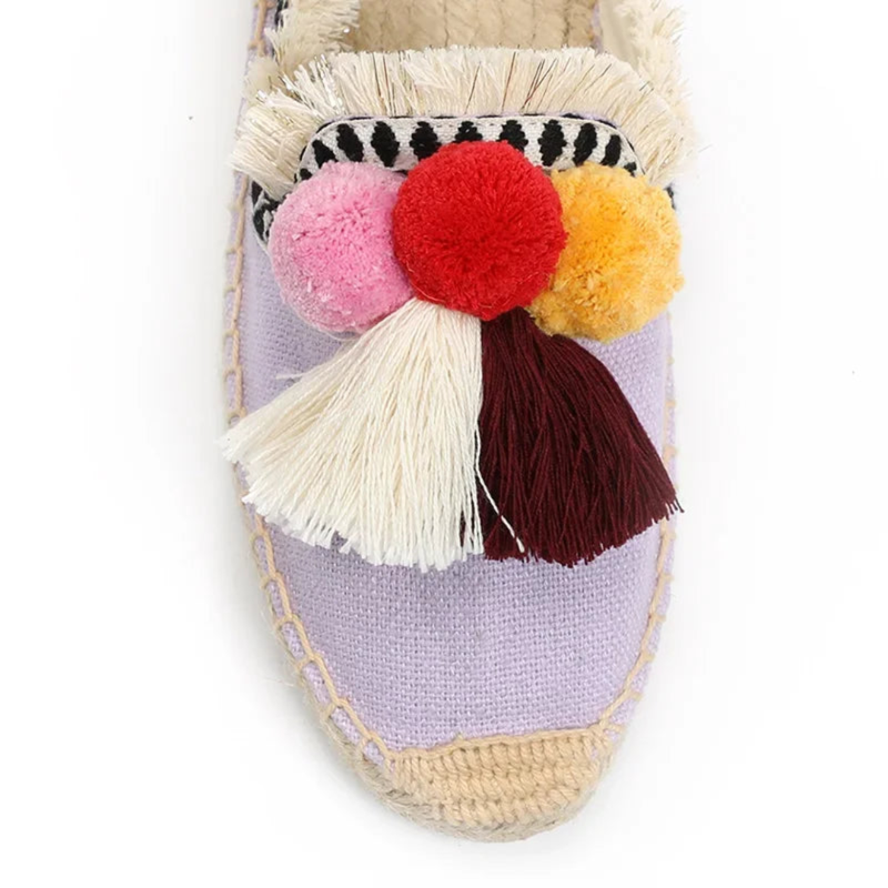 Close-up of lilac mule toe with pom-poms and fringe
