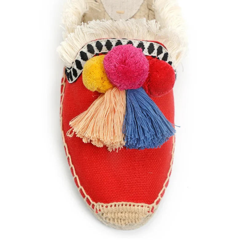 Close-up of red mule with blue tassel and pom-poms