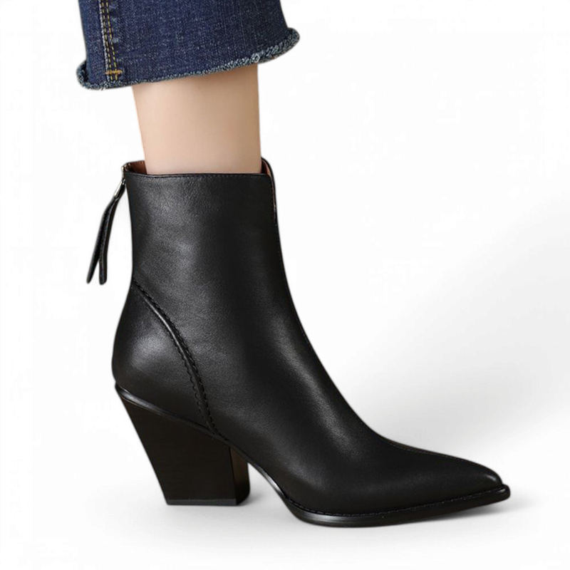 A black leather boot shown at an angled front-side perspective, highlighting the slanted heel and narrow toe.