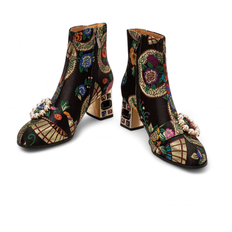 Black embroidered ankle-boot pair on white background showing multicolour gem heels and pearl buckle.