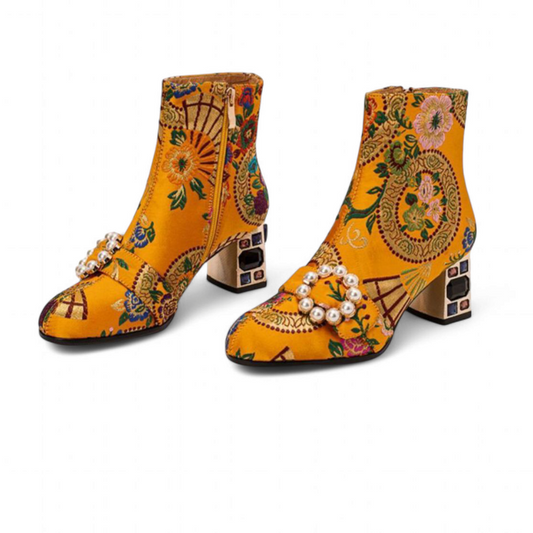 Yellow embroidered ankle-boot pair on white background, pearl buckles and jewel-set