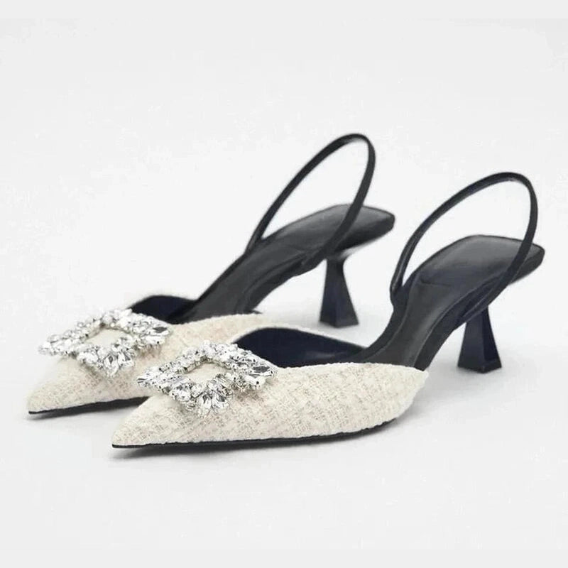 Ivory pearl-embellished slingbacks photographed flat on white background