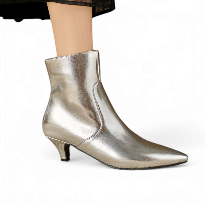 Silver metallic ankle boot on foot, kitten heel visible.