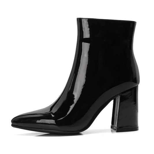 Clean profile of black patent boot highlighting heel curve.