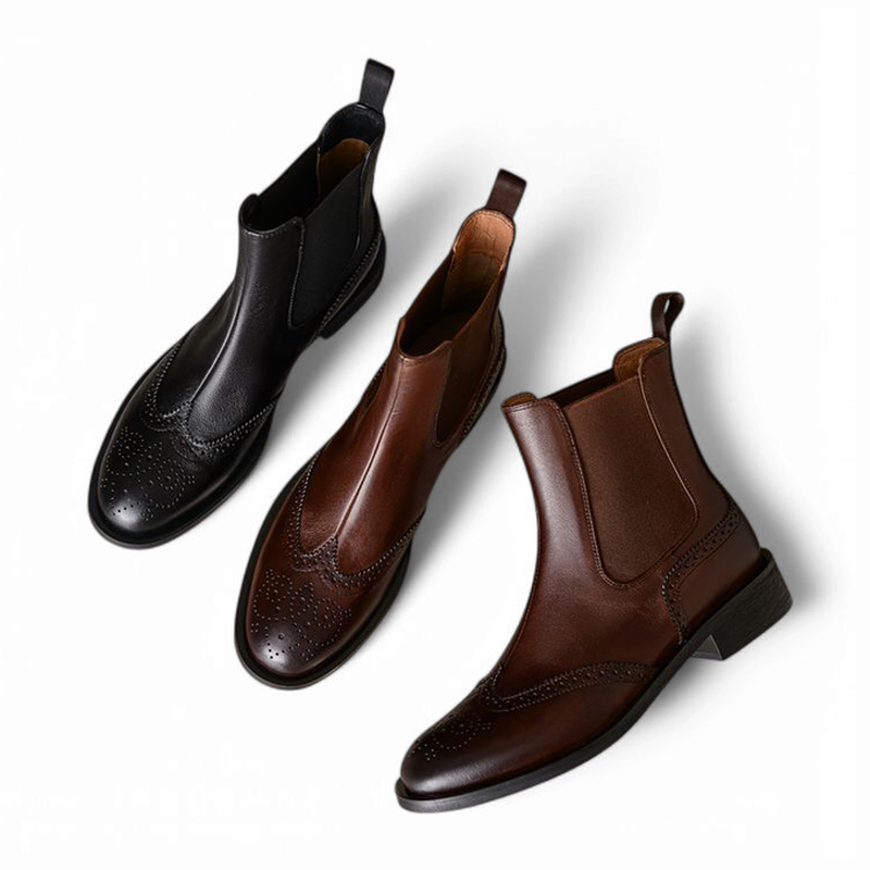 Top view of black and brown Chelsea boots side by side on white background