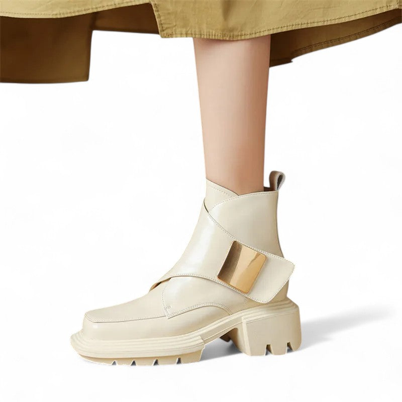 Glossy white ankle boot worn on foot with geometric design and thick heel