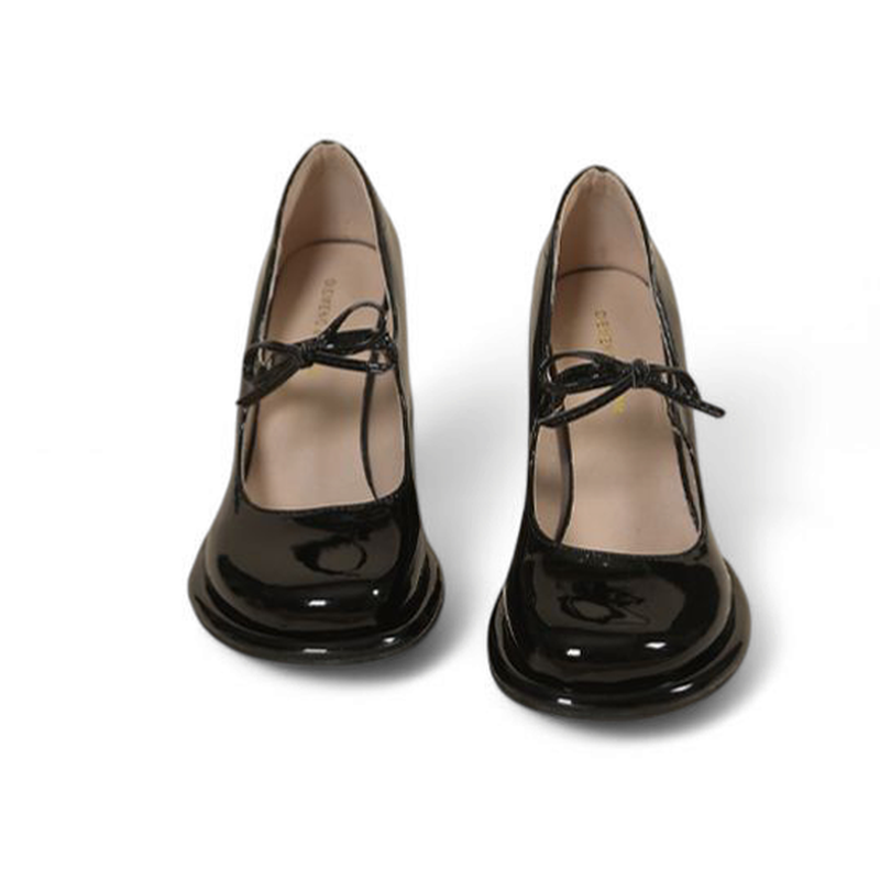 Front view of glossy black Mary-Jane pair showing bow ties.