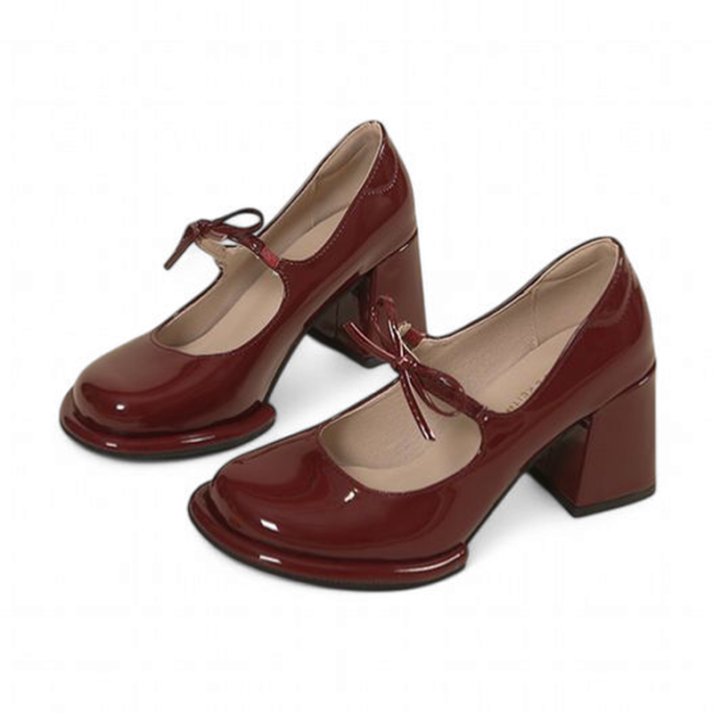 side view of glossy burgundy Mary-Jane pair highlighting bow ties.

