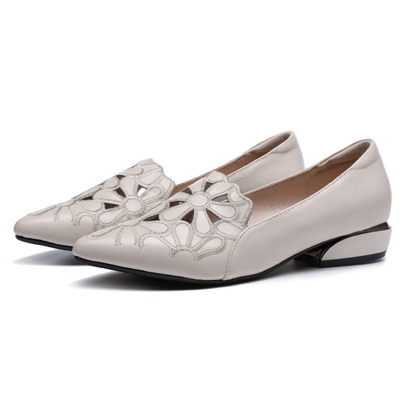 Ivory pointed flats with low heel, angled pair.