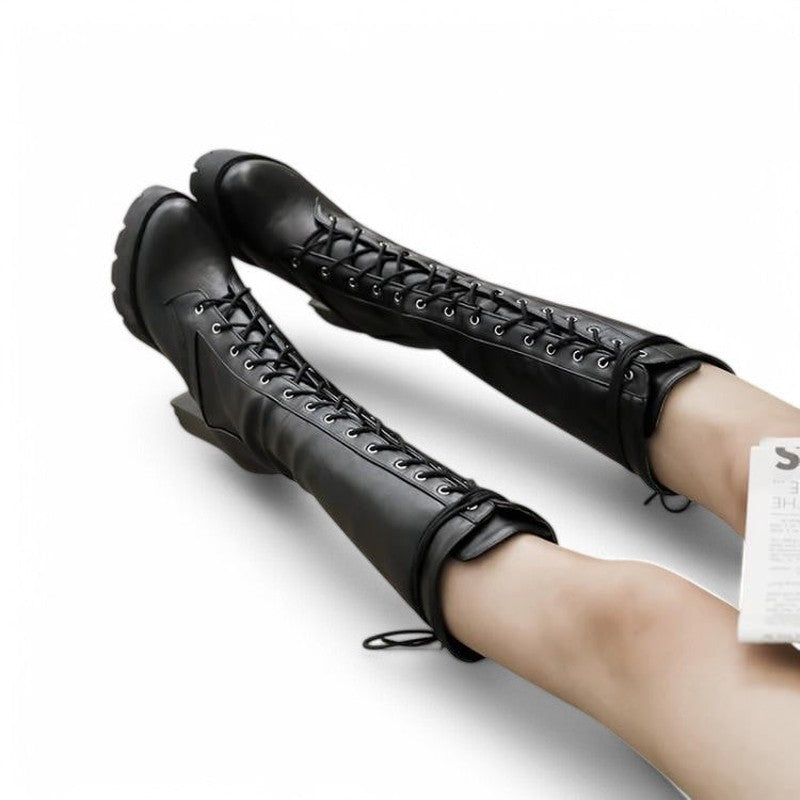 A woman wearing a black knee-high lace-up boot with a thick platform heel, styled in a sleek Victorian-inspired silhouette.