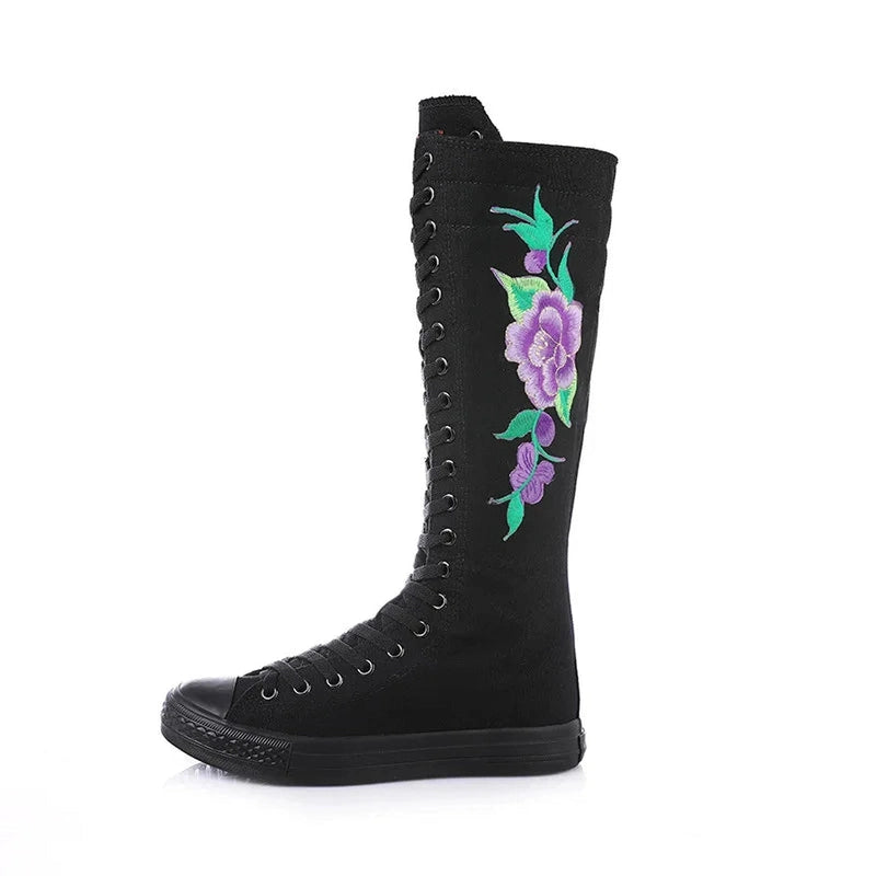 Black knee-high canvas boot with full front lacing and purple floral side embroidery.