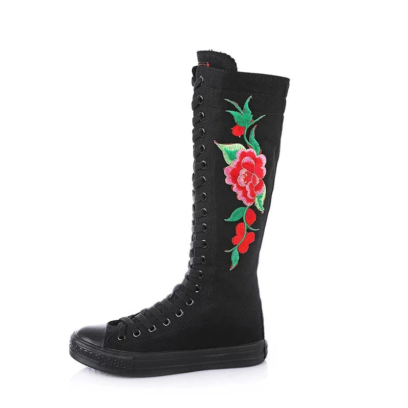 Side profile of black canvas boot with vivid red flower embroidery.
