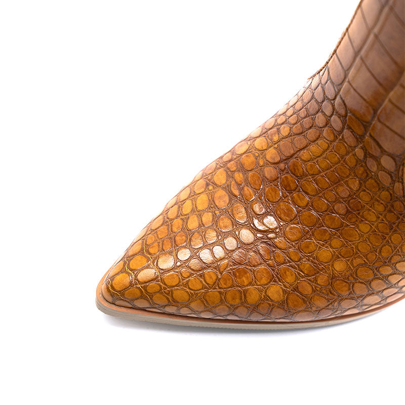 Detailed close-up of the pointed toe of a brown leather boot.
