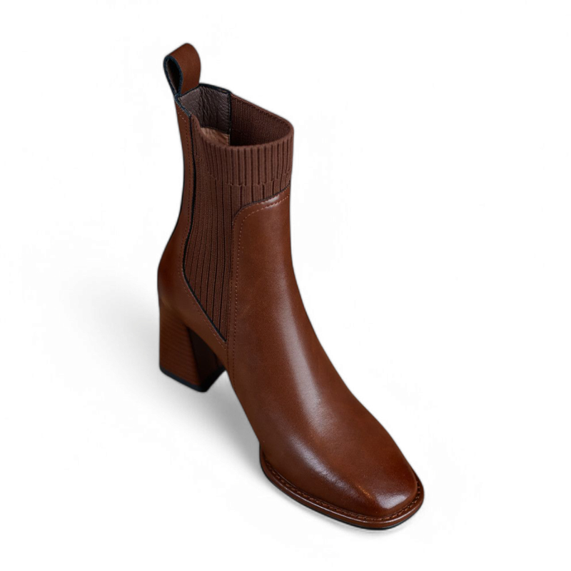 Front view of a single brown Merendy Elomda Chelsea boot, showing the structured square toe and smooth leather texture.