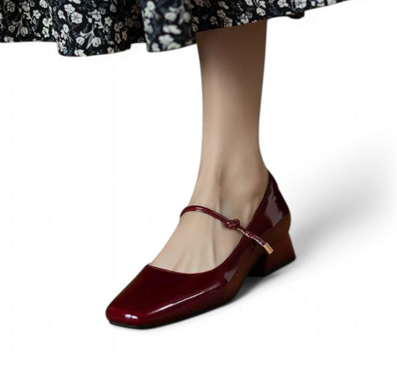 Glossy burgundy Mary-Jane with square toe and mid block heel, worn with floral dress.