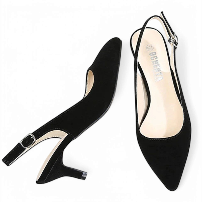 Flat-lay of black pointed-toe slingback pump with kitten heel, one shoe angled