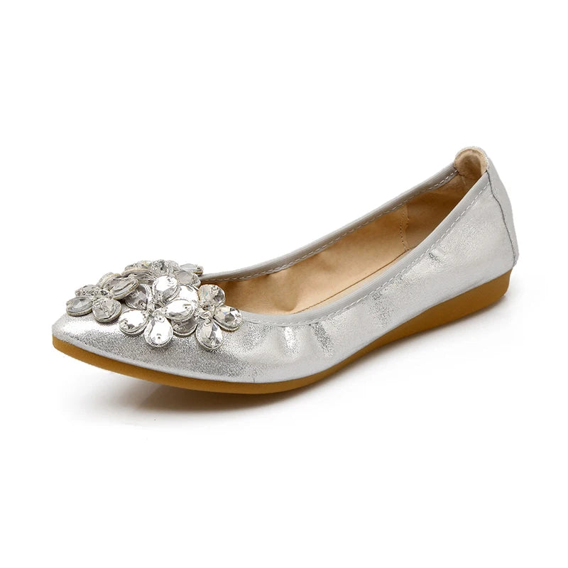 Silver ballet flat with prominent crystal-petal embellishment on the toe, photographed from the side.