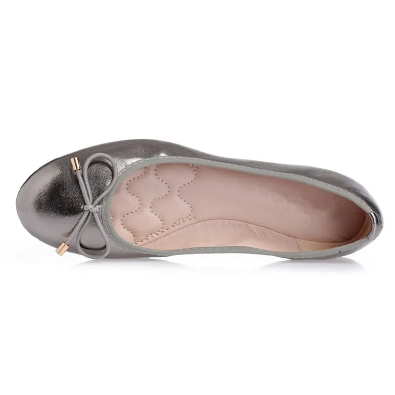Top view showing padded insole with wave stitching and bow with metal tips.
