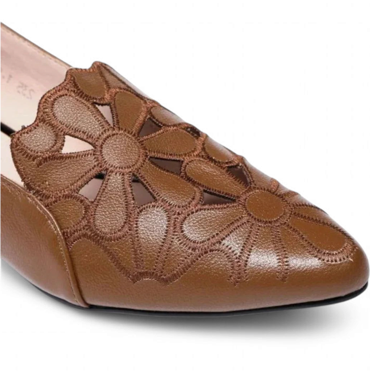  Pointed toe with floral cutouts on the brown upper.