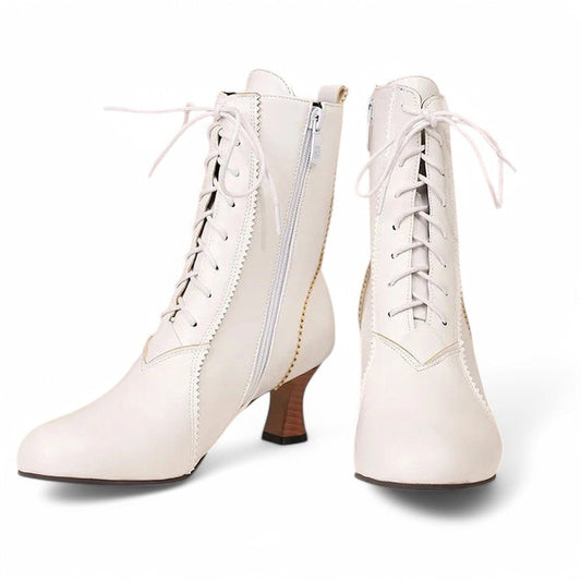 A pair of Merendy Samira white Victorian boots displayed on a plain background. One boot shows the front with a lace-up design, while the other reveals the side view with zipper and square heel. Round toe shape, scalloped trim, and subtle stitching are clearly visible.