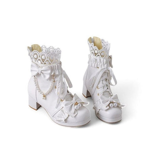 A full-frontal view of white Victorian-inspired boots with floral lace, pearl bows, and ruffled cuff details.