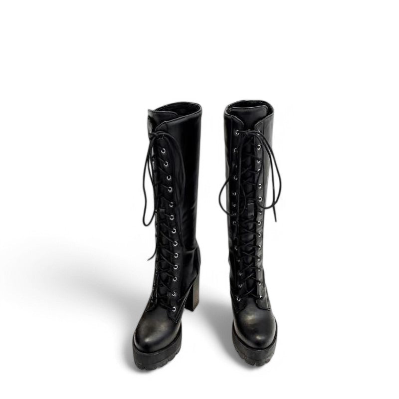 Two black Victorian-style knee-high boots placed side by side, viewed from the front, showing the lace-up detailing and sleek leather finish.