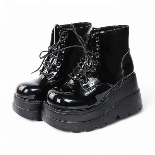 Side view of glossy black platform boots positioned together.