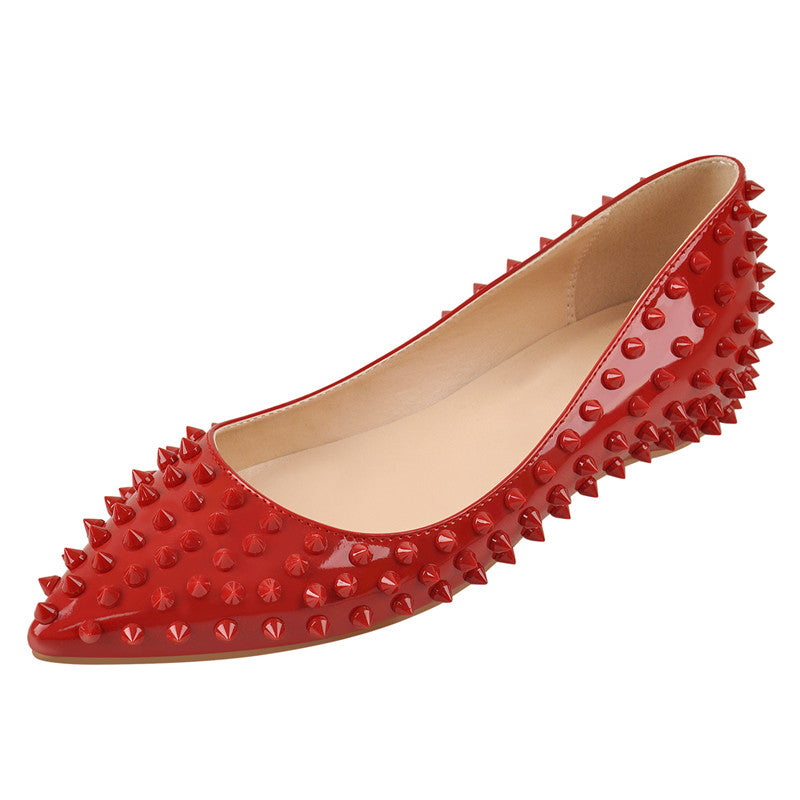 Shiny red pointed-toe flat with conical studs along the sides.